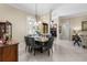 Well-lit dining room with a modern chandelier and views into the living room at 3418 Turningwind Ln, Winter Garden, FL 34787
