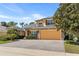 A charming yellow two-story home with black shutters, a two car garage, and manicured front yard at 3418 Turningwind Ln, Winter Garden, FL 34787