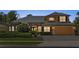 A delightful two-story home with stone accents, warm lighting, and well-maintained landscaping at 3418 Turningwind Ln, Winter Garden, FL 34787