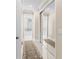 Hallway featuring a mirrored closet and a glimpse into the bathroom with a freestanding tub at 3418 Turningwind Ln, Winter Garden, FL 34787