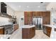 A modern kitchen with custom wood cabinetry, stainless steel appliances, and a marble countertop island at 3418 Turningwind Ln, Winter Garden, FL 34787