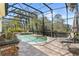 Relaxing enclosed pool area featuring a brick outdoor kitchen, luxurious lounge chairs, and tropical landscaping at 3418 Turningwind Ln, Winter Garden, FL 34787