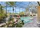 A gorgeous screened-in pool with lush landscaping, a rock waterfall, and plenty of space to lounge around at 3418 Turningwind Ln, Winter Garden, FL 34787