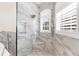 Walk-in shower with rainfall showerhead, bench seating, and window at 3418 Turningwind Ln, Winter Garden, FL 34787