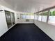 Enclosed lanai featuring durable black carpet, white walls and multiple windows for ample natural light at 3530 Forest Branch Dr # F, Port Orange, FL 32129