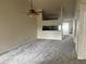 Spacious living room with neutral carpet, a ceiling fan, and a decorative wall cutout to the kitchen at 3530 Forest Branch Dr # F, Port Orange, FL 32129