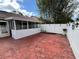 Private patio area with a decorative brick-patterned surface and a white fence for added privacy at 3530 Forest Branch Dr # F, Port Orange, FL 32129