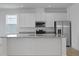 Bright kitchen featuring white cabinetry, stainless steel appliances, and granite island at 364 Lemongrass Rd, Minneola, FL 34715