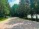 Long winding brick driveway lined with mature trees leading up to a home with a lake view at 4 Island Dr, Lake Mary, FL 32746