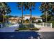 Stunning estate with white fence and brick driveway, showcased with palm trees against a clear, sunny sky at 4 Island Dr, Lake Mary, FL 32746