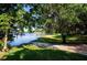Scenic lake view framed by lush trees, showcasing a tranquil waterfront and a distant gazebo at 4 Island Dr, Lake Mary, FL 32746