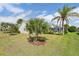 Lush backyard with palm trees, a green lawn, and an enclosed, screened-in patio at 433 Arcadia Lakes Dr, The Villages, FL 32162
