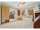 Bedroom with a large mirrored closet and windows covered with beige patterned curtains at 433 Arcadia Lakes Dr, The Villages, FL 32162