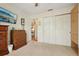 Bedroom with neutral carpet, a flat screen television, and a view through a door into another room at 433 Arcadia Lakes Dr, The Villages, FL 32162