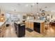 Open kitchen with tile floor, wooden cabinets, stainless steel appliances, and a central island with a butcher block top at 433 Arcadia Lakes Dr, The Villages, FL 32162