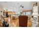 Inviting living area featuring wood floors, a ceiling fan, and comfortable seating, adjacent to the open kitchen at 433 Arcadia Lakes Dr, The Villages, FL 32162