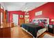 Bright main bedroom with hardwood floors, a ceiling fan, and a large window overlooking the yard at 433 Arcadia Lakes Dr, The Villages, FL 32162