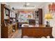 Well-appointed home office features custom built-in shelves, a large desk, and a plush chair, bathed in natural light at 433 Arcadia Lakes Dr, The Villages, FL 32162