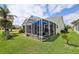 Backyard view of the screened-in patio, providing a cozy and private outdoor space at 433 Arcadia Lakes Dr, The Villages, FL 32162