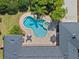 Aerial view of a kidney shaped pool and spa in a backyard that features two outdoor seating areas and lush landscaping at 4350 New Broad St, Orlando, FL 32814