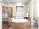 A luxurious bathroom features a soaking tub, glass shower, and shuttered windows at 4350 New Broad St, Orlando, FL 32814