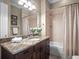 Bathroom featuring tile flooring, dark wood vanity, granite countertop and a bathtub/shower combo at 4350 New Broad St, Orlando, FL 32814