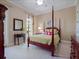 Bright bedroom features a classic four-poster bed, neutral walls, and plush carpeting at 4350 New Broad St, Orlando, FL 32814