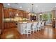 Open kitchen features a center island with chairs, wood cabinets and a large stainless steel hood at 4350 New Broad St, Orlando, FL 32814
