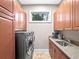 Well-equipped laundry room with front-loading washer and dryer, sink, and ample cabinet space at 4350 New Broad St, Orlando, FL 32814
