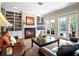 Living room featuring a fireplace with built-in bookshelves and french doors that lead to the outdoor pool at 4350 New Broad St, Orlando, FL 32814