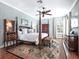 Comfortable main bedroom featuring a four-poster bed, ceiling fan, and hardwood floors with an area rug at 4350 New Broad St, Orlando, FL 32814