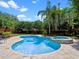 An outdoor swimming pool and hot tub surrounded by lush landscaping at 4350 New Broad St, Orlando, FL 32814