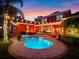 This backyard boasts a large, private pool with a spa, a brick-paver patio and string lights for outdoor entertaining at twilight at 4350 New Broad St, Orlando, FL 32814