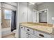 Bathroom with vanity, granite countertop, and a shower-tub combination behind a dark curtain at 440 Skyview Pl, Chuluota, FL 32766