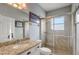 Bright bathroom featuring a granite countertop, white cabinets, and glass-enclosed shower at 440 Skyview Pl, Chuluota, FL 32766