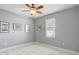 Empty carpeted bedroom with a ceiling fan, light grey walls, and a bright window at 440 Skyview Pl, Chuluota, FL 32766