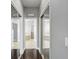 Hallway featuring hardwood floors and mirrored closet doors leading to bathroom at 440 Skyview Pl, Chuluota, FL 32766