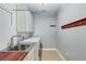 Functional laundry room features stainless steel sink, washer, dryer and hanging rack at 440 Skyview Pl, Chuluota, FL 32766