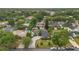 A high altitude aerial view of the home with a curved driveway and swimming pool nestled within a vibrant, tree-filled neighborhood at 4436 Larado Pl, Orlando, FL 32812