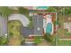 Aerial view of backyard with pool, deck, screened-in porch, fenced-in yard, manicured landscaping, and curved driveway at 4436 Larado Pl, Orlando, FL 32812