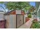 Outdoor shed with double doors and a walkway to the house with garden, tools, and well-maintained landscaping at 4436 Larado Pl, Orlando, FL 32812