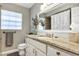 Bathroom featuring a vanity with granite countertop, large mirror, and white cabinetry at 445 Songbird Way, Apopka, FL 32712