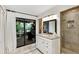 Well-lit bathroom with white vanity, granite countertop, and a sliding glass door to the patio at 445 Songbird Way, Apopka, FL 32712