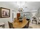 Elegant dining room with chandelier, wooden table, and bay window providing natural light at 445 Songbird Way, Apopka, FL 32712