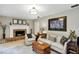 Cozy living room featuring a brick fireplace, comfortable seating, and stylish decor at 445 Songbird Way, Apopka, FL 32712