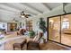 The covered lanai features wicker furniture, ceiling fans, a clock, and sliding door access to interior rooms at 445 Songbird Way, Apopka, FL 32712
