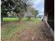 Large, grassy backyard featuring mature trees and view to neighboring homes at 5120 Lazy Lake Cir, Orlando, FL 32821