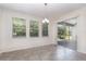 Elegant dining area featuring tile floors, a modern chandelier, and a sliding glass door to the patio at 5871 Alenlon Way, Mount Dora, FL 32757