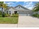 Charming home with a well-manicured lawn, stone accents, and a three-car garage, creating a welcoming curb appeal at 5871 Alenlon Way, Mount Dora, FL 32757