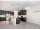 Gourmet kitchen with granite countertops, stainless steel appliances, dark wood cabinetry, and tile flooring at 5871 Alenlon Way, Mount Dora, FL 32757